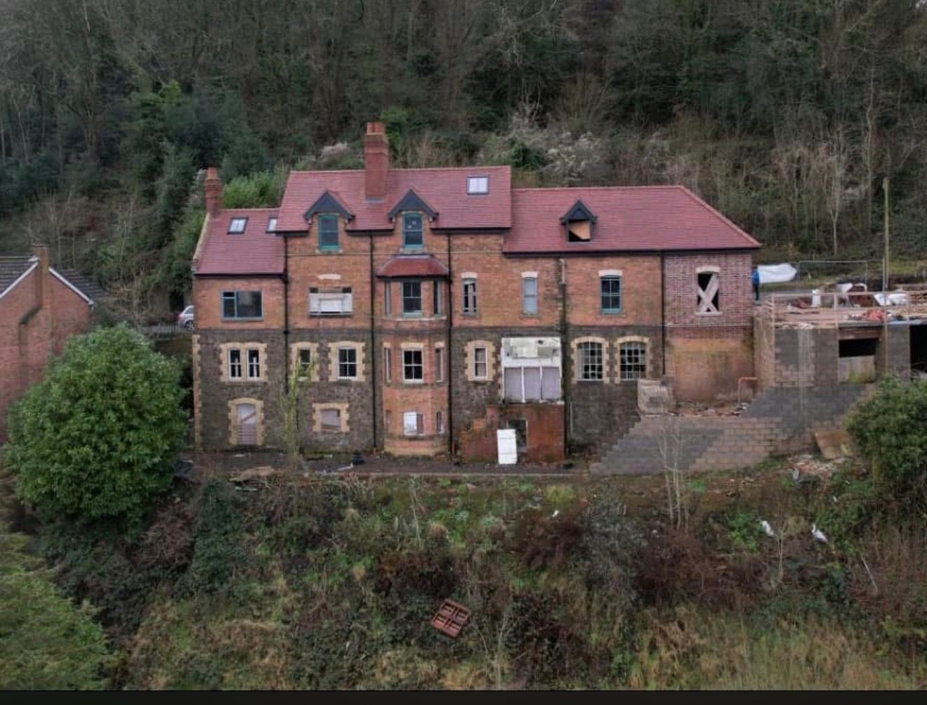Aerial view of a large Victorian brick house re-roofed in red clay tiles, with new dormers, rooflights and rebuilt chimney stacks